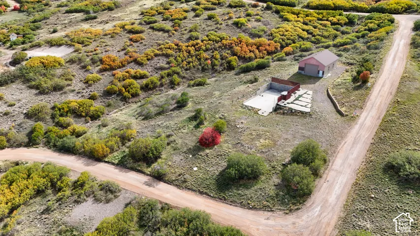 Expansive acreage featuring a detached garage, concrete foundation, retaining wall, and gravel site access