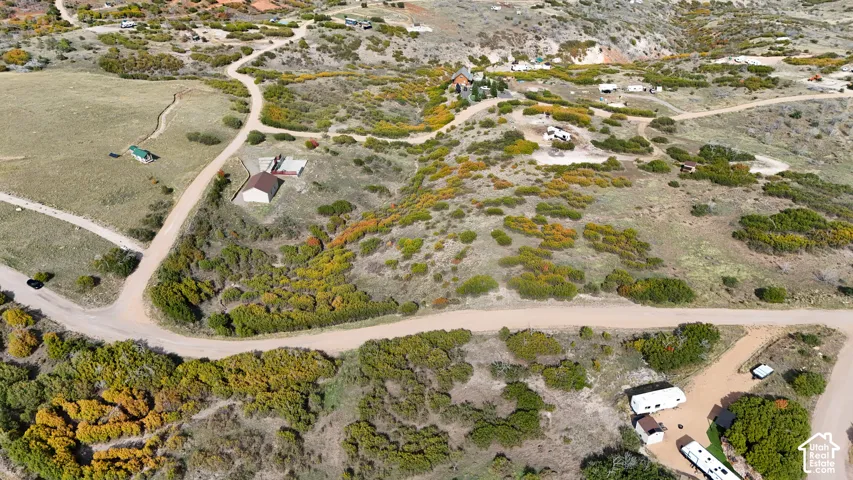 Aerial perspective of expansive rural acreage featuring rolling topography, native vegetation, natural landscape, and gravel access roads