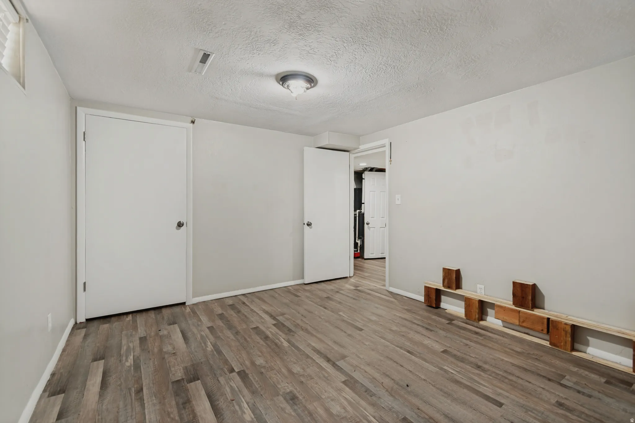 Wood-finish flooring, neutral wall tones, and recessed lighting