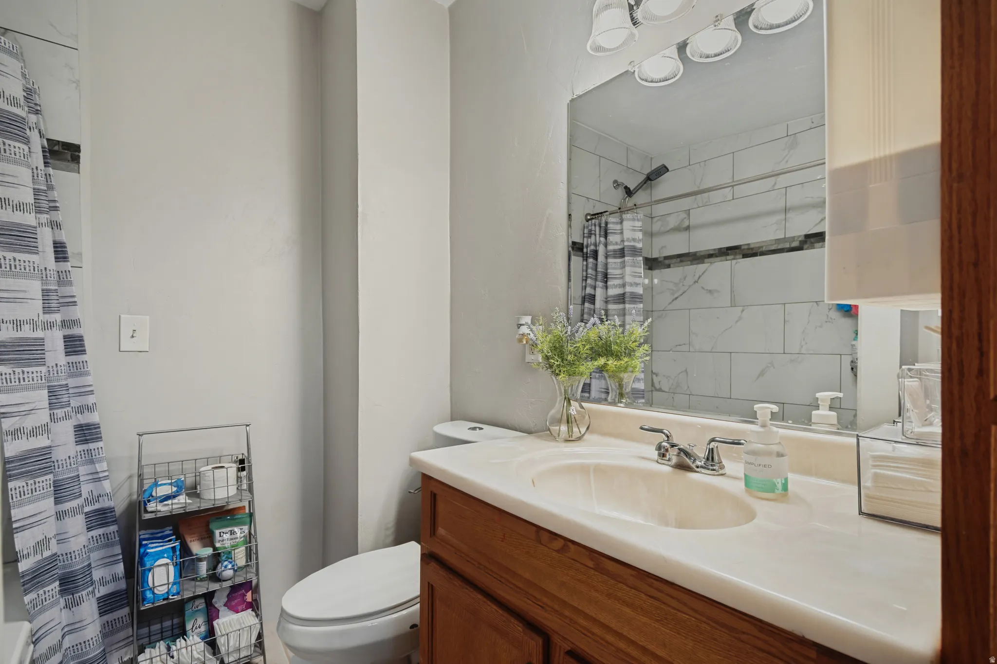 Bathroom featuring a vanity with an integrated sink, polished chrome faucet, and a large wall-mounted mirror
