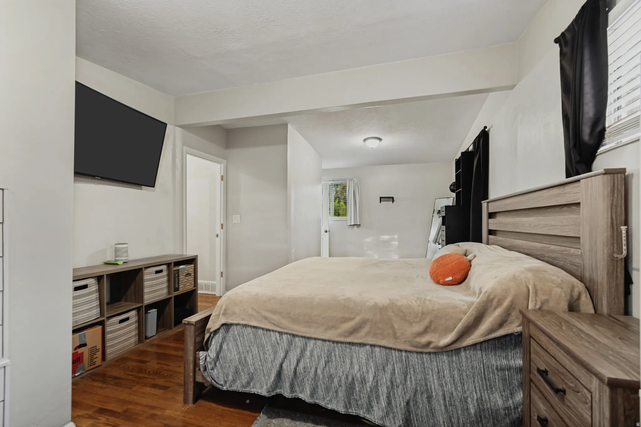 Hardwood flooring, recessed lighting, built-in storage shelving, and a mounted flat-screen television