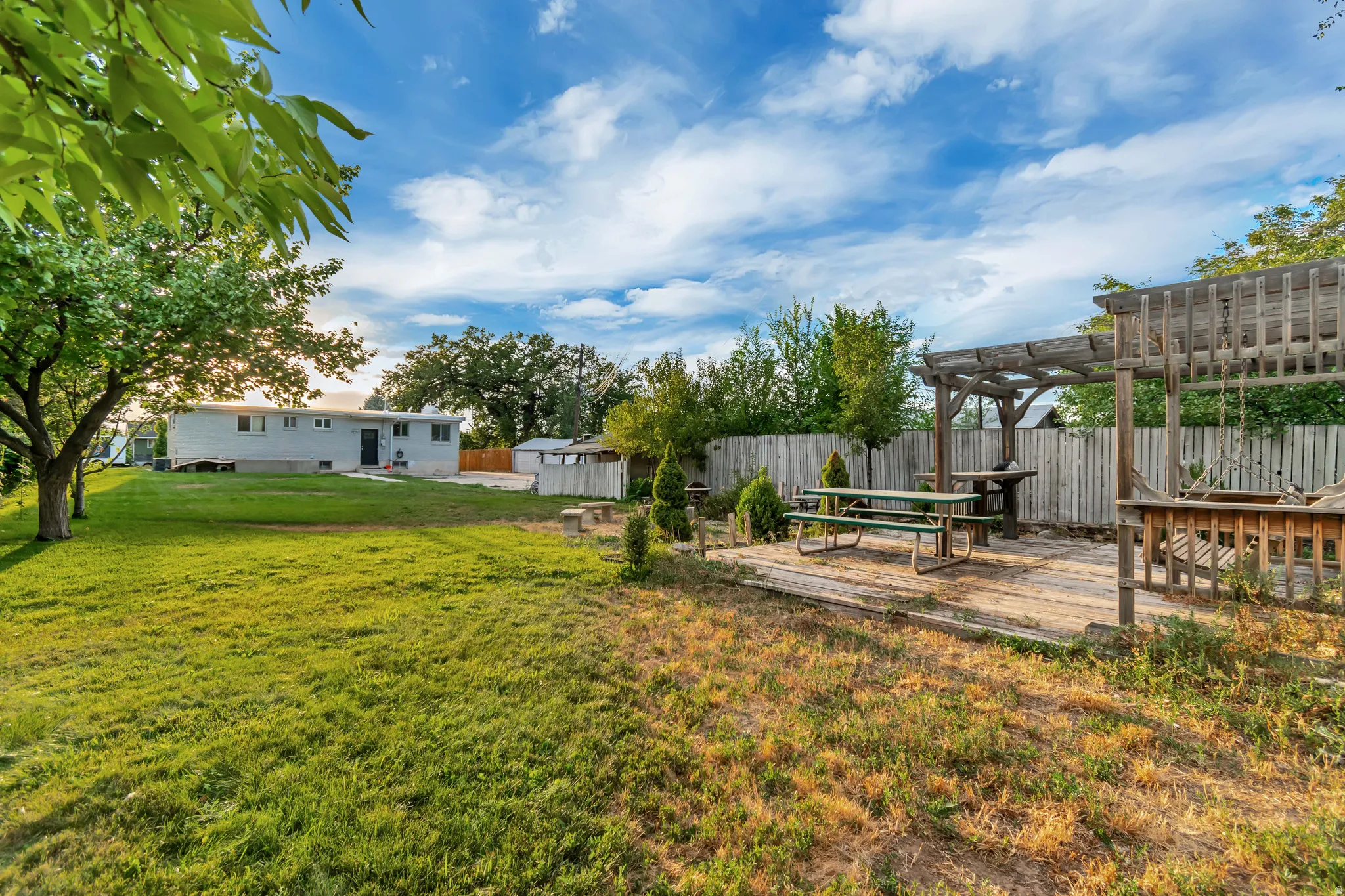 Spacious yard with a wood patio and pergola