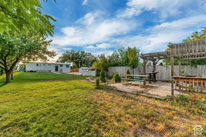 Spacious yard with a wood patio and pergola