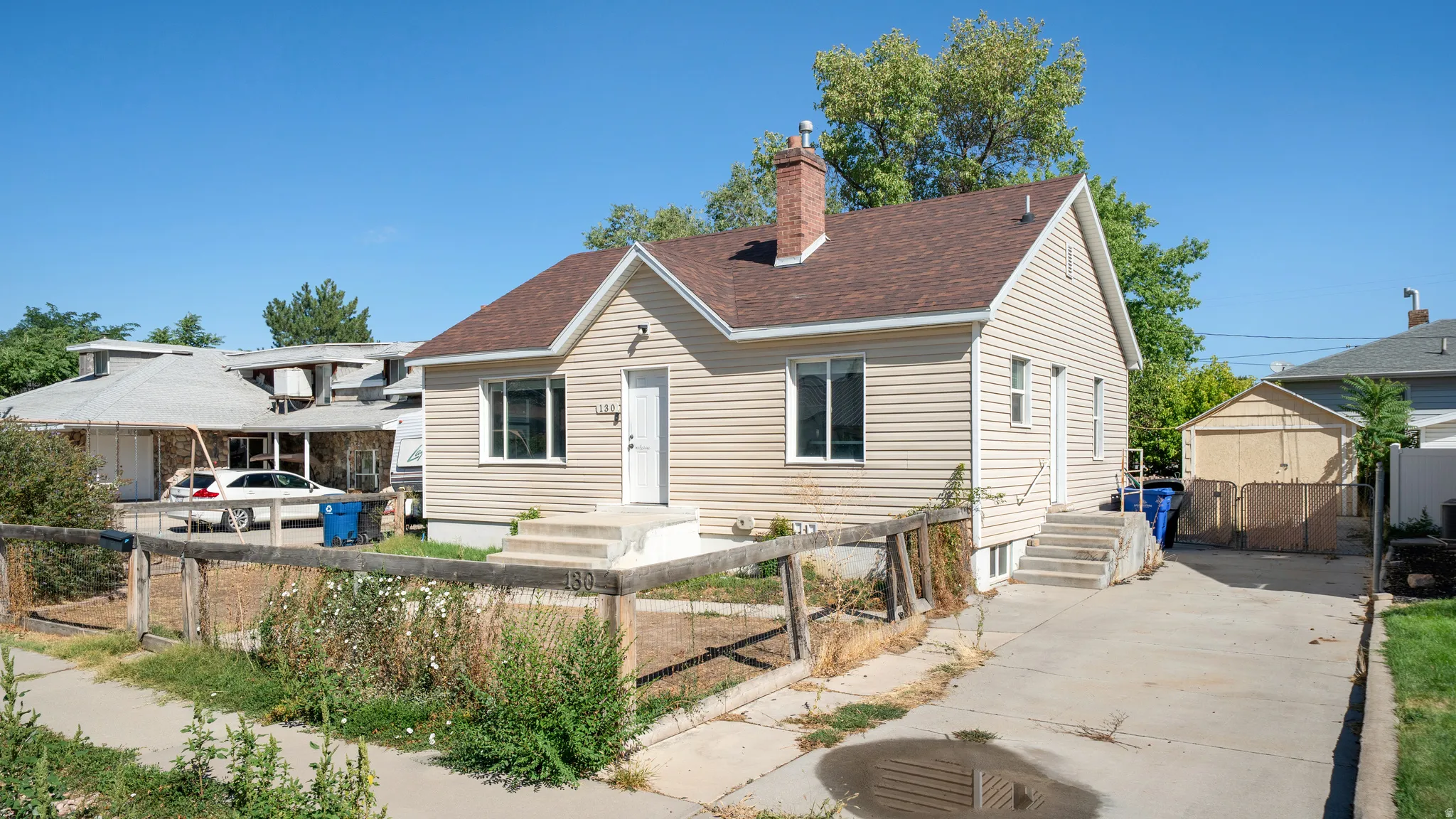 Siding exterior with a brown shingle roof and a concrete driveway