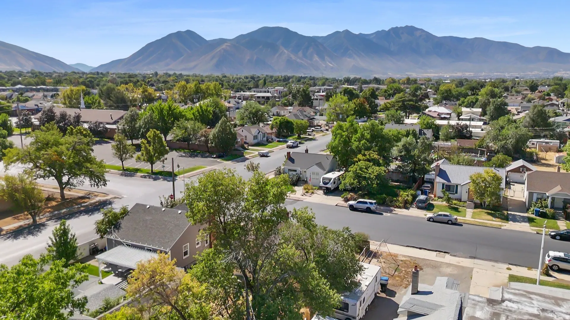 Expansive neighborhood with mature trees and mountain backdrop