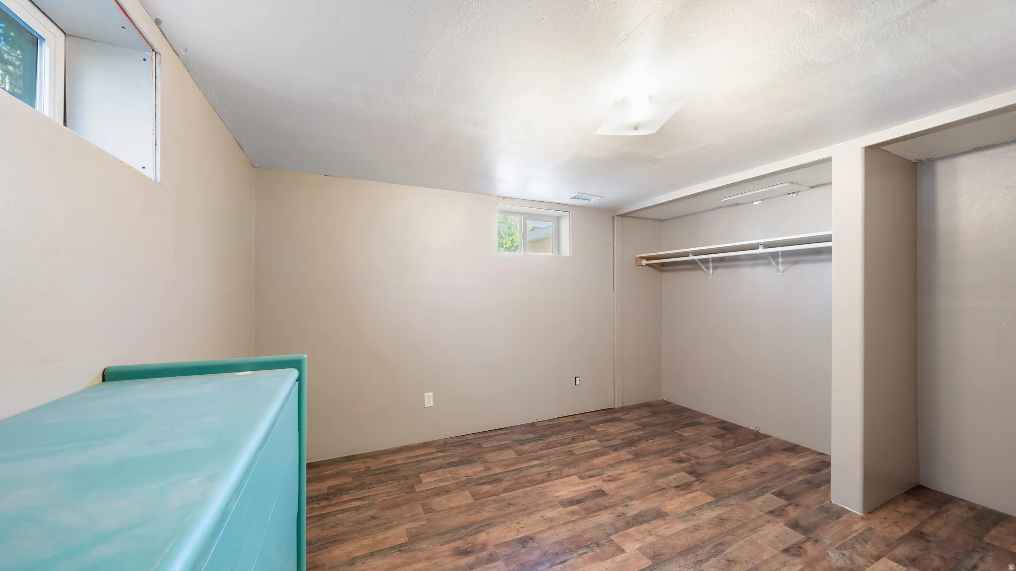 Wood-finish flooring, neutral wall paint, recessed ceiling light, and built-in closet shelving