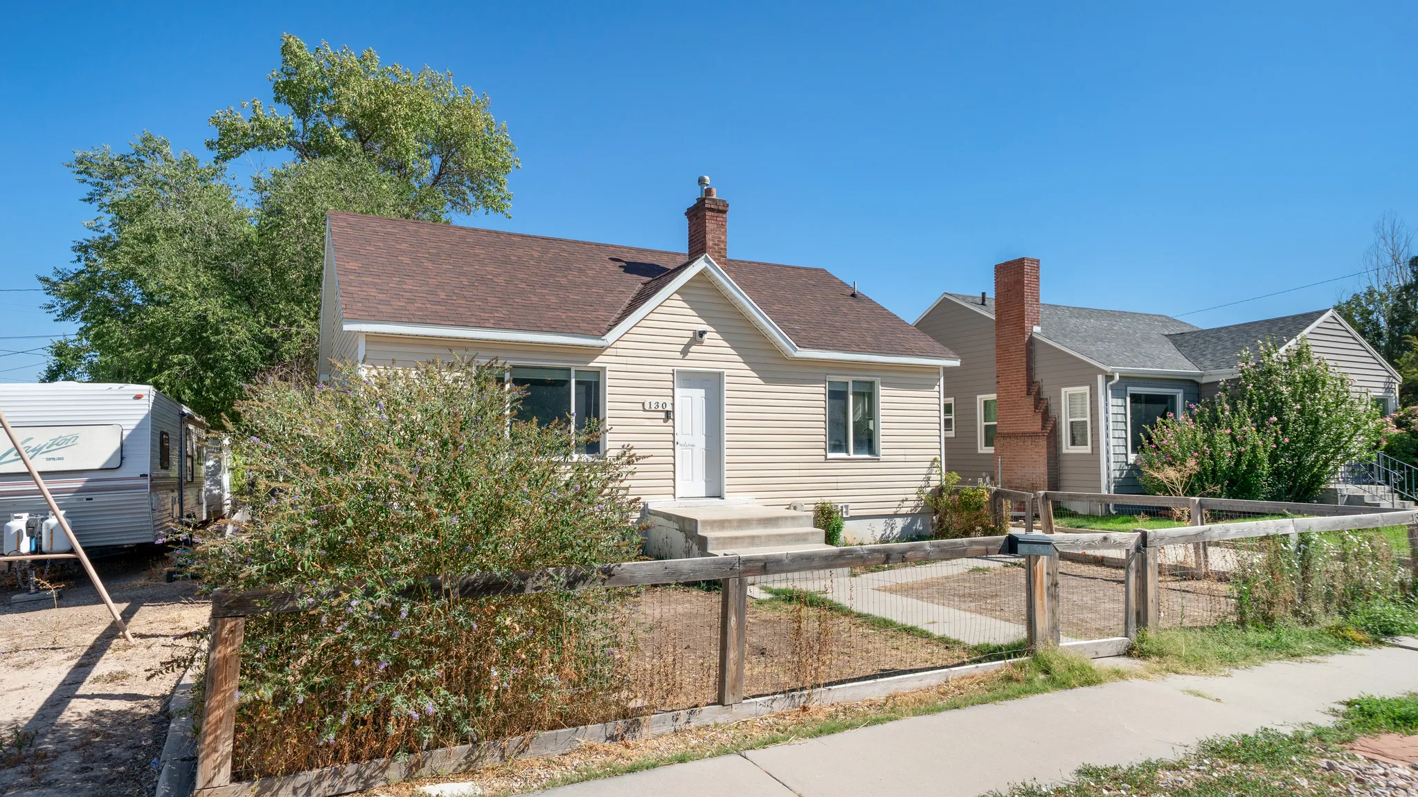 Exterior featuring horizontal siding, a gabled roof, and a red brick chimney