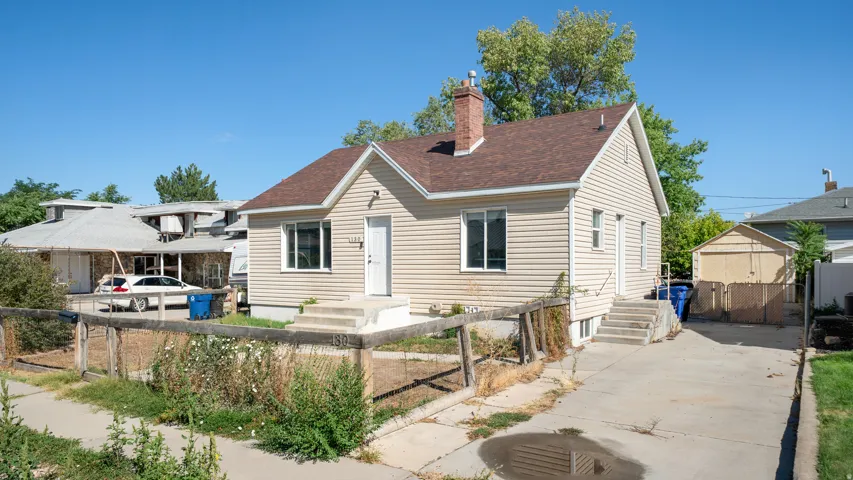 Siding exterior with a brown shingle roof and a concrete driveway