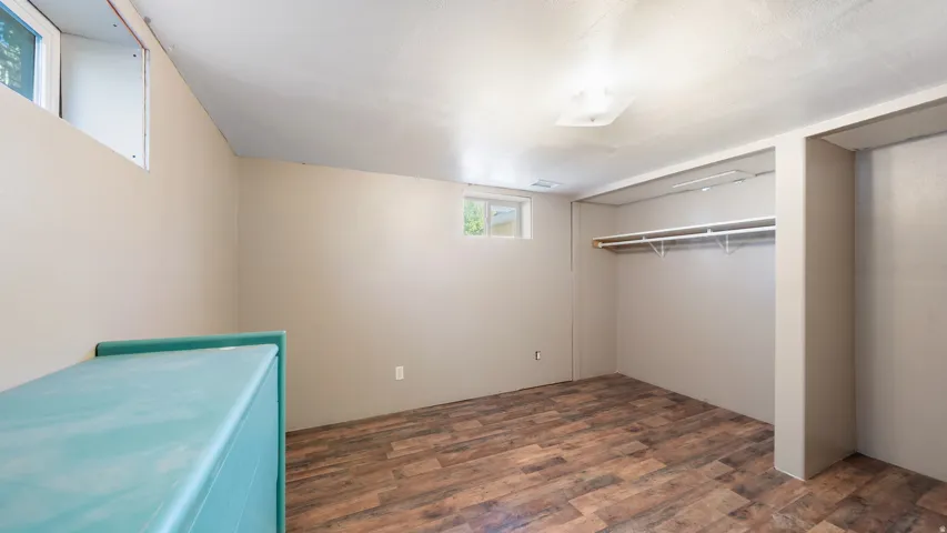 Wood-finish flooring, neutral wall paint, recessed ceiling light, and built-in closet shelving