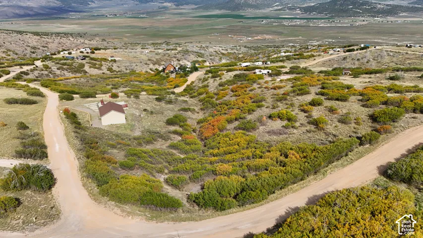 Expansive acreage featuring rugged terrain, native scrub brush, established dirt access roads, and mountain topography