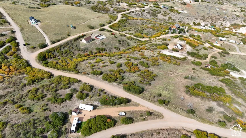 Aerial perspective of expansive acreage featuring native vegetation, rolling terrain, and dirt access roads