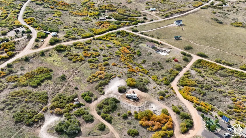 Expansive rural landscape featuring rolling topography, native vegetation, natural rock outcroppings, and dirt access roads