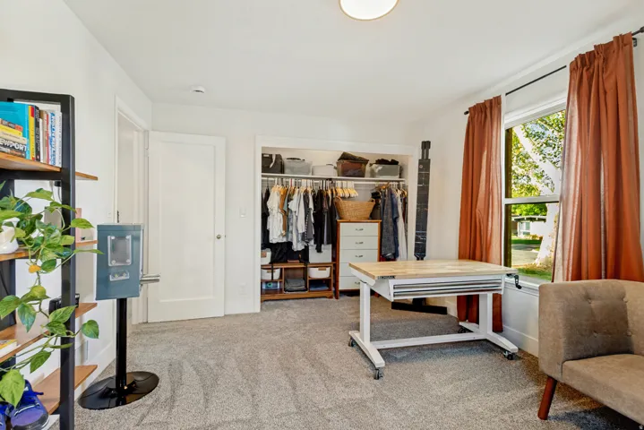 Recessed closet with built-in shelving, white trim, light wall color, and carpeted flooring
