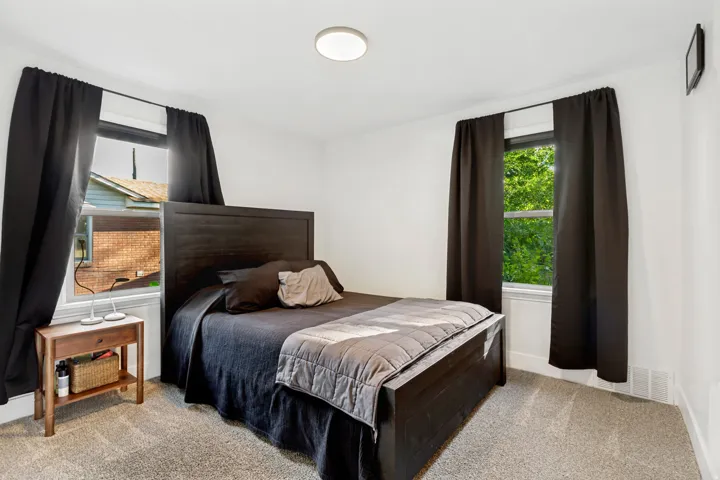 Bright room with two windows, wall-to-wall carpeting, and a flush-mount ceiling light fixture