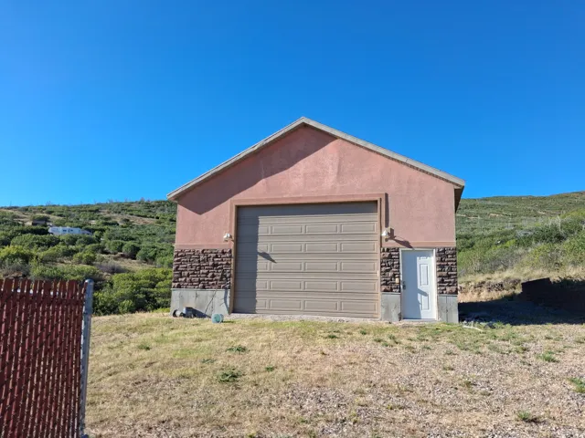 Gable roof structure with stucco siding and stone veneer accents
