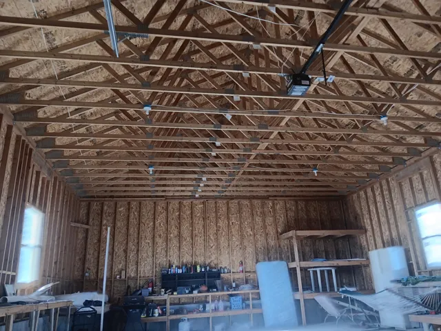 Exposed wood truss ceiling, wood-finish wall panels, built-in shelving, two windows