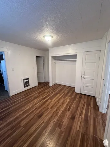 Wood-finish flooring with a closet featuring a hanging rod