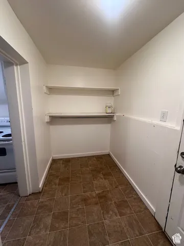 Utility area featuring two built-in shelves, tiled flooring, and a painted finish
