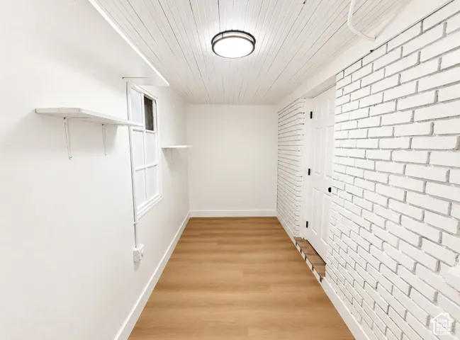Light wood-finish flooring with white baseboards