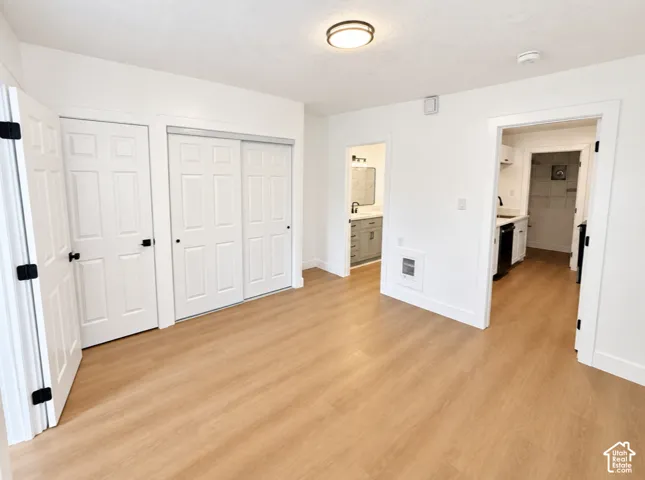 Wood-finish flooring throughout, white paneled doors, and a flush-mount ceiling light