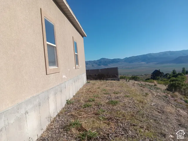 Stucco exterior with a concrete foundation, featuring double-pane windows and expansive mountain scenery