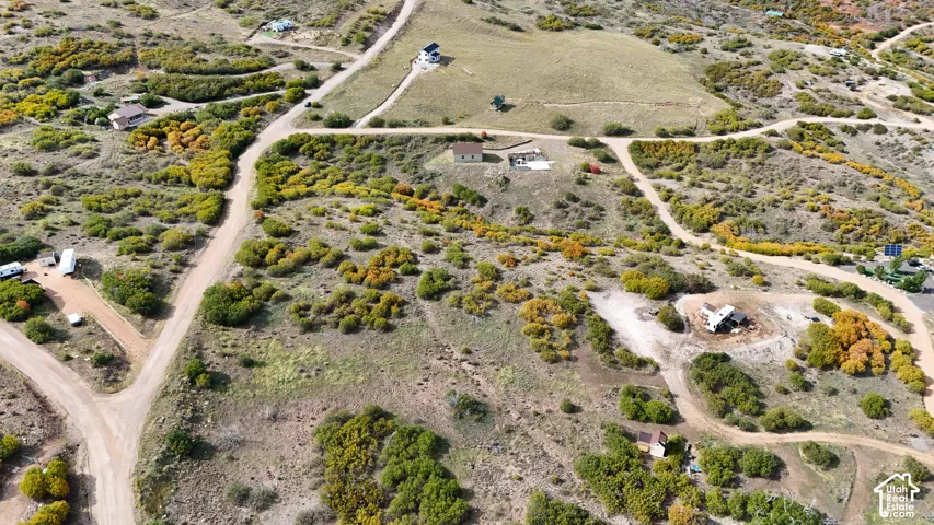 Aerial perspective of expansive lot featuring rolling terrain, native vegetation, and unpaved access roads