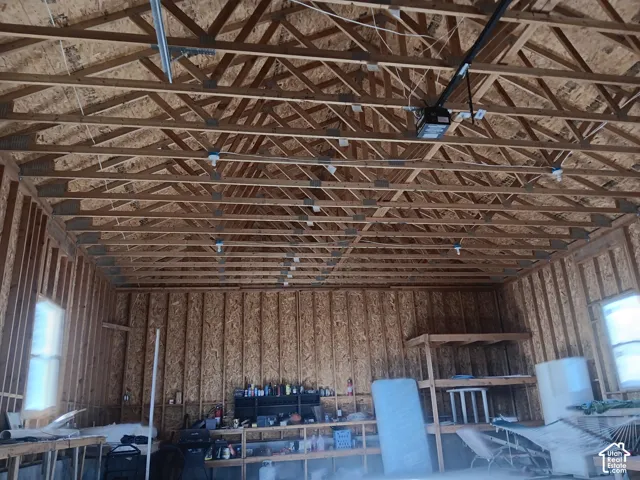 Exposed wood-truss ceiling, unfinished oriented strand board walls, and integrated storage shelving