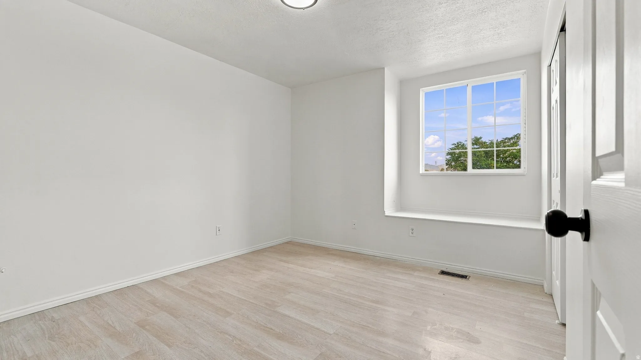 Light wood-finish flooring with white walls