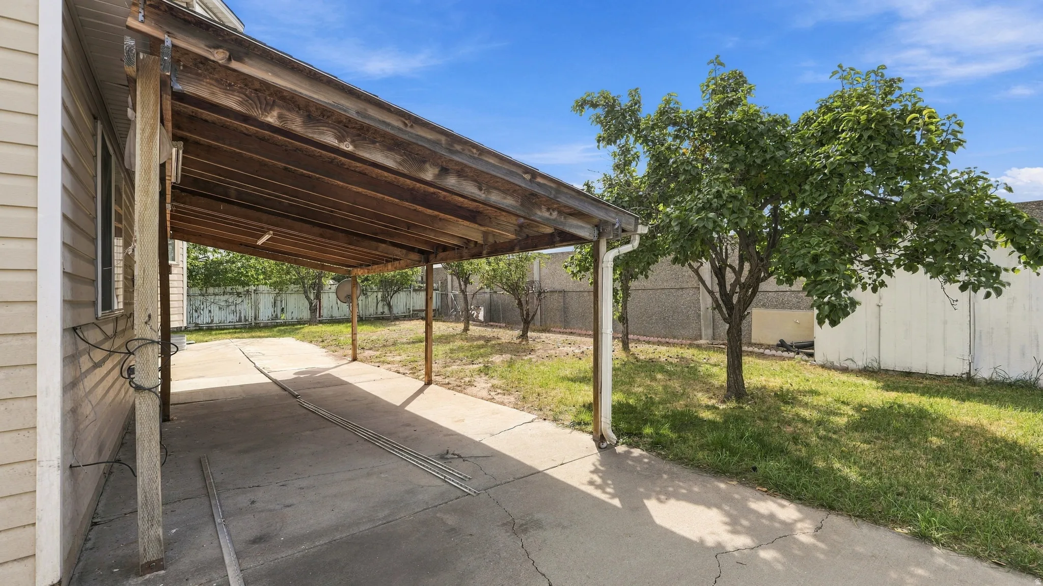 Attached carport with a concrete driveway and gutter system