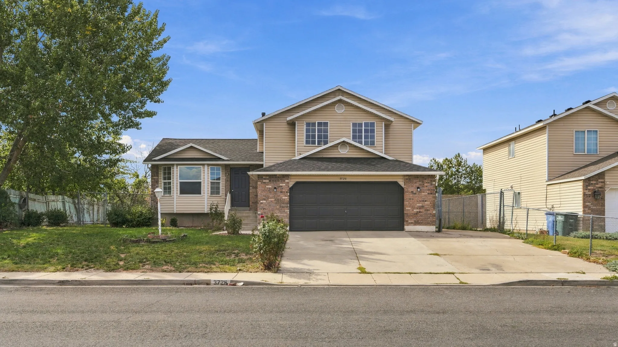 Two-story residence featuring a two-car garage, brick and siding exterior, and a concrete driveway