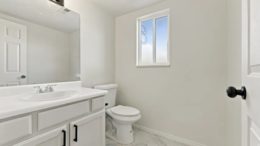White shaker-style vanity with a white countertop and undermount sink