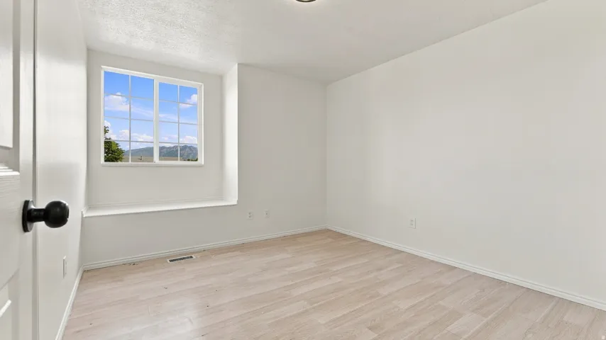 Light wood-finish flooring with white walls and trim