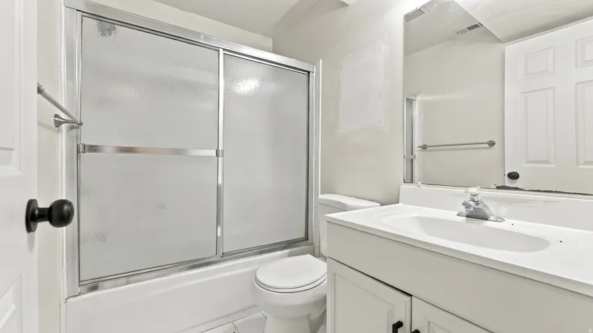 White vanity with a single basin sink and chrome faucet
