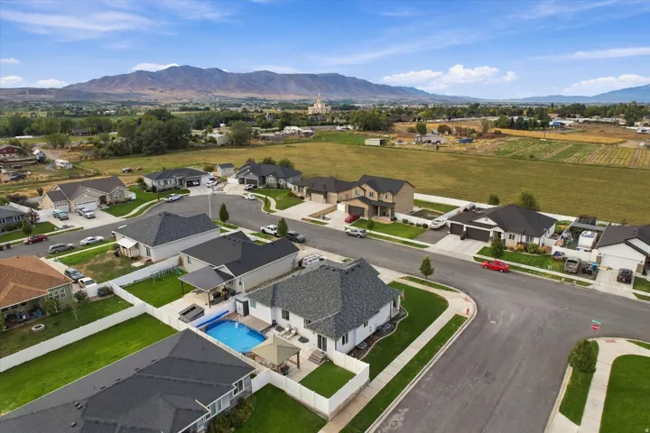 Backyard swimming pool, mountain backdrop, manicured lawns, paved streets, and a well-defined neighborhood layout