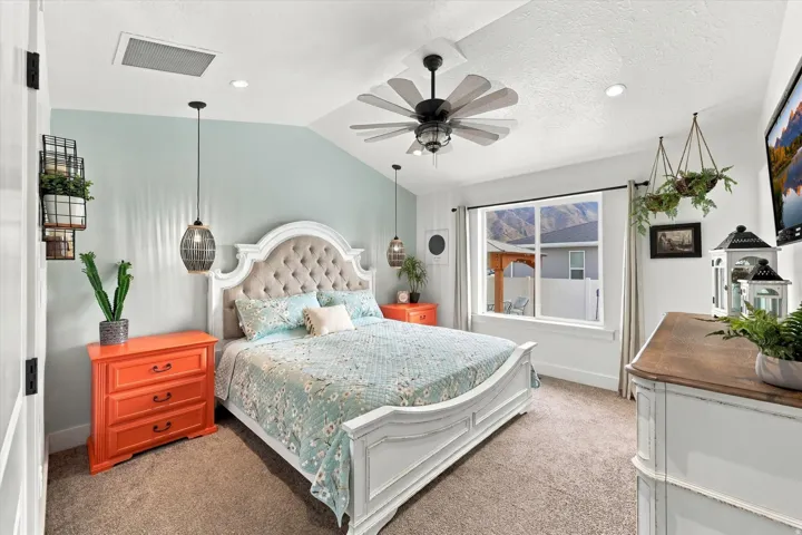 Vaulted ceiling with a ceiling fan, recessed lighting, and a large window