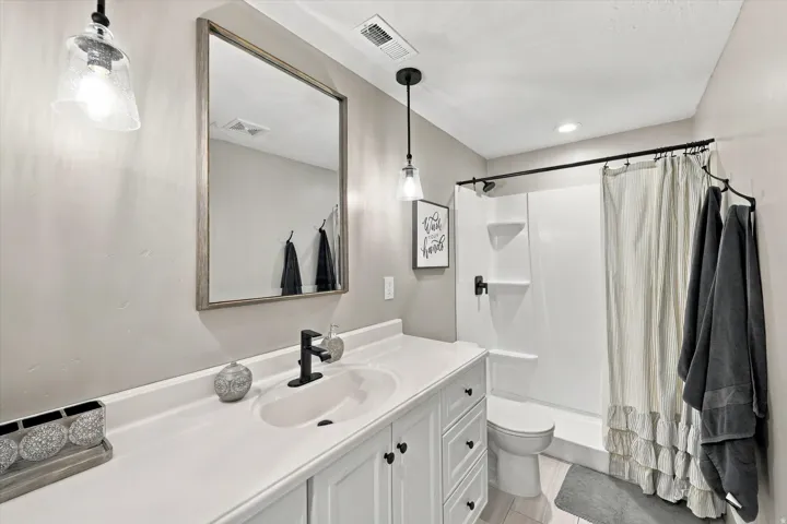 White vanity with black hardware, integrated sink, and matte black faucet