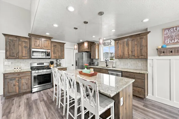 Kitchen featuring wood-finish flooring, recessed lighting, and a center island with a stone countertop