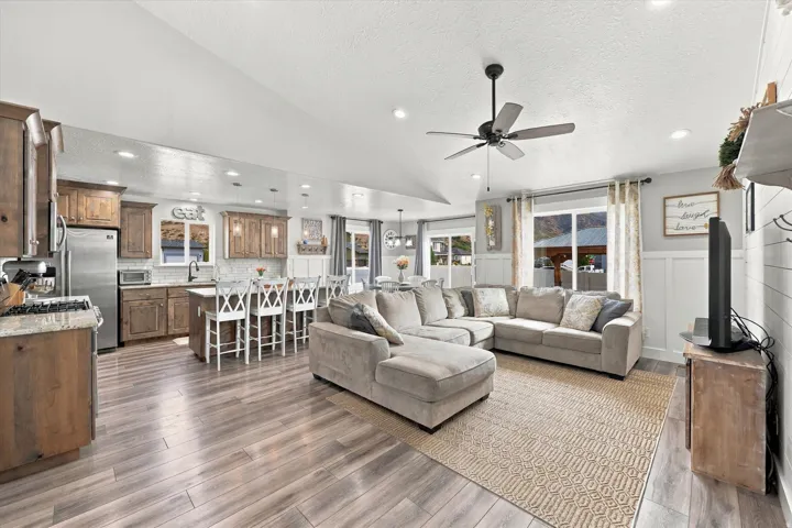 Open-concept living area featuring wood-finish flooring, recessed lighting, and a ceiling fan