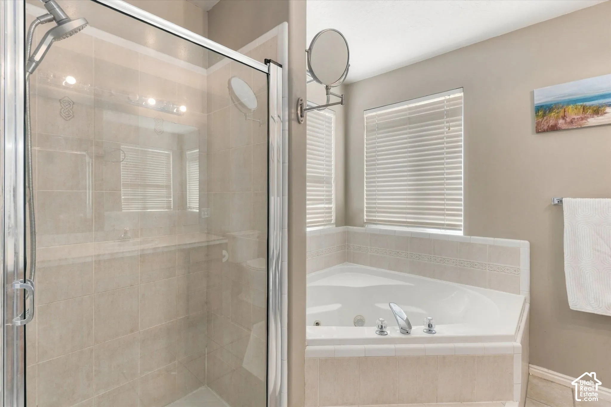 Glass-enclosed shower with a chrome shower head and tiled walls