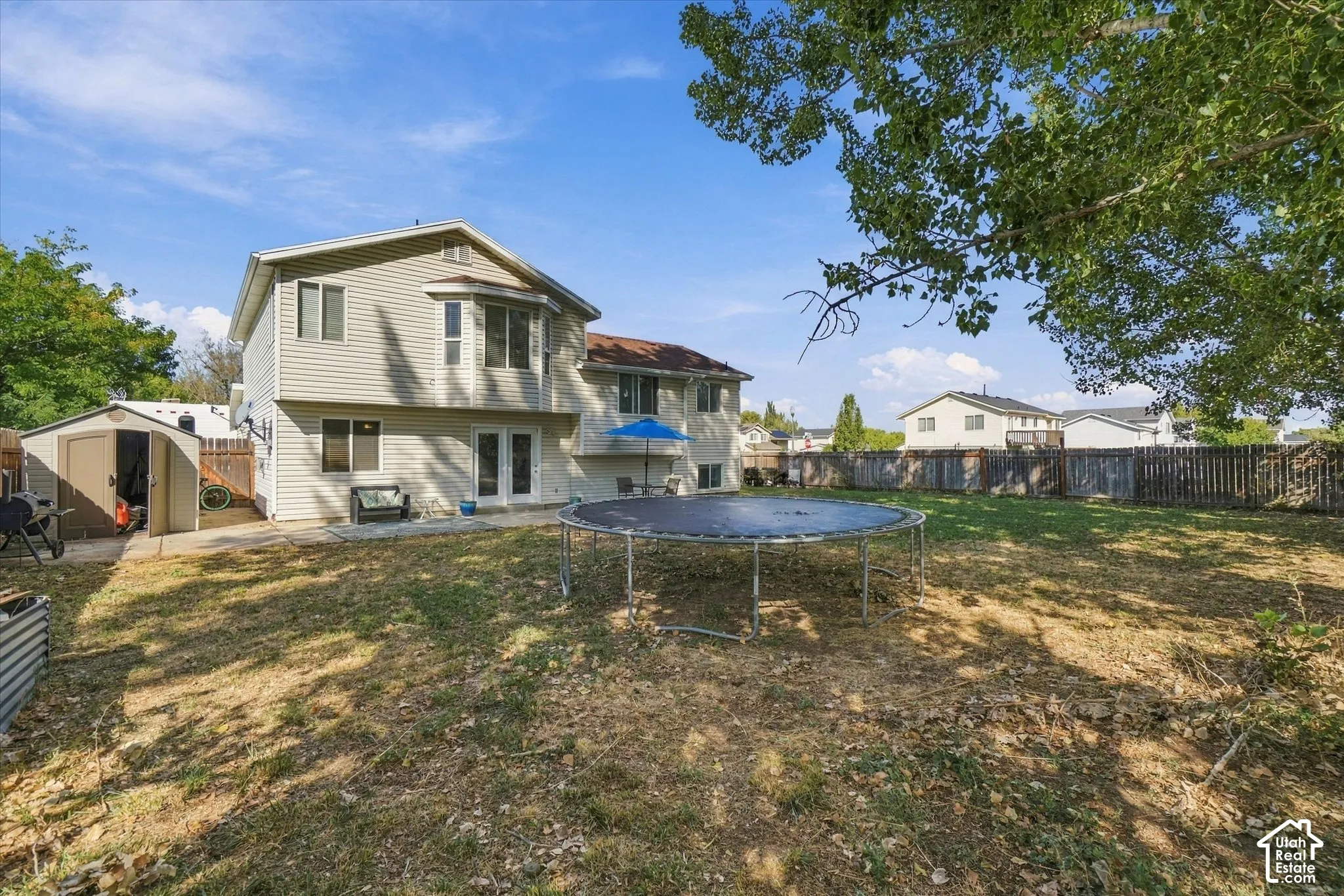 Expansive backyard featuring a two-story home with siding, a bay window, and a storage shed