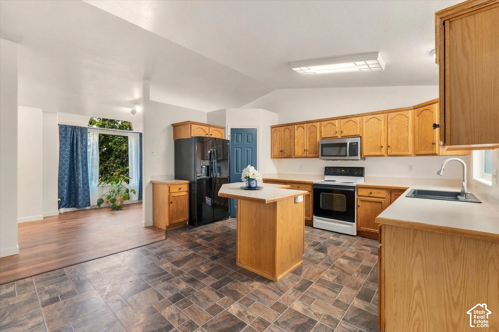 Kitchen with wood cabinetry, stainless steel appliances, and a central island