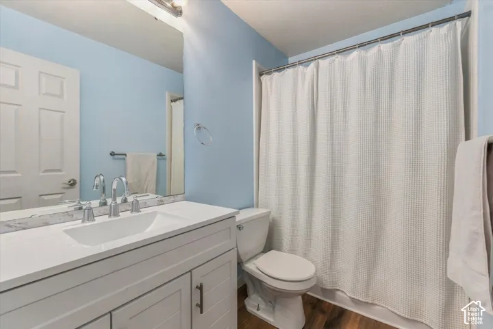 White vanity with panel detailing, integrated rectangular sink, chrome hardware, and a framed mirror