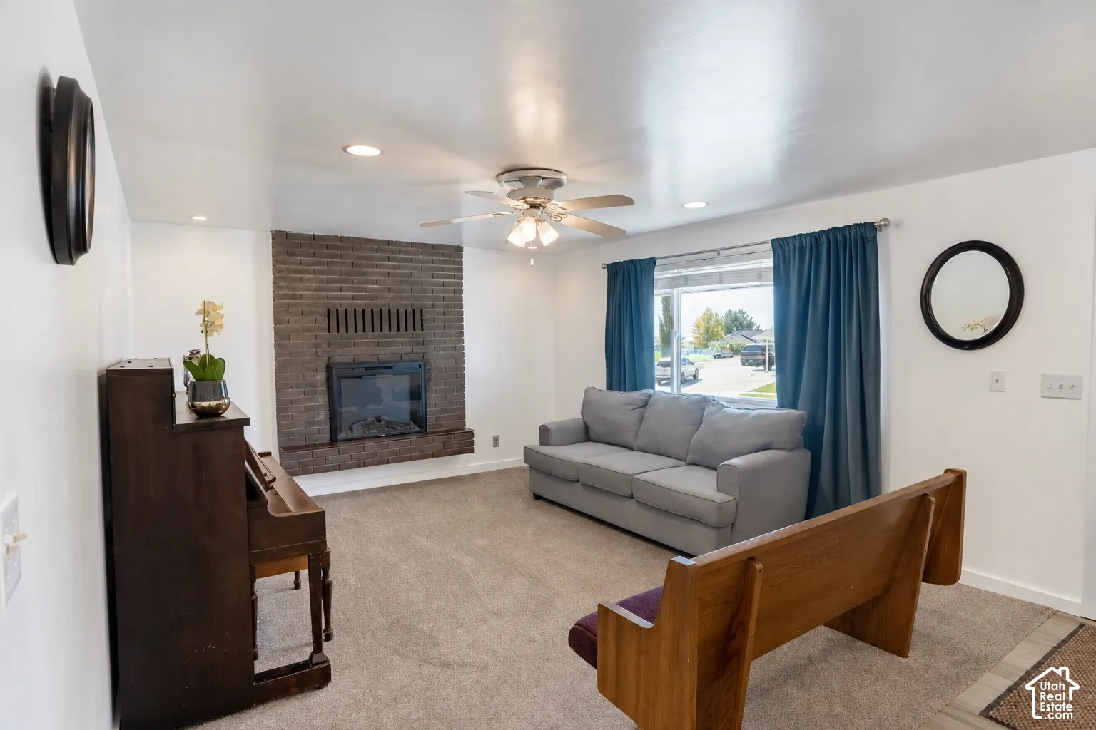 Brick-faced fireplace with a built-in firebox, recessed lighting, and a ceiling fan