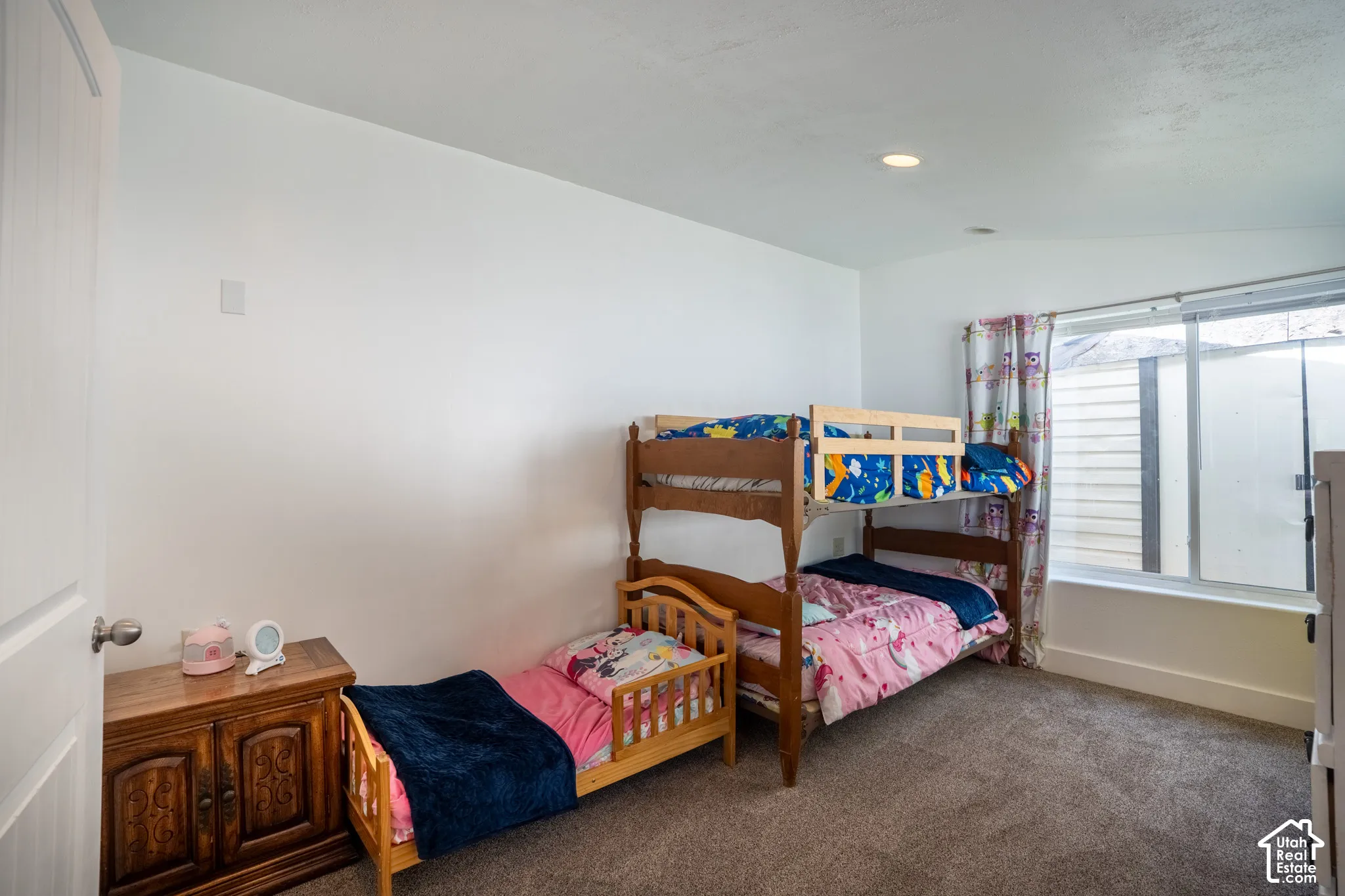 Recessed ceiling lighting, white walls, and gray carpeting