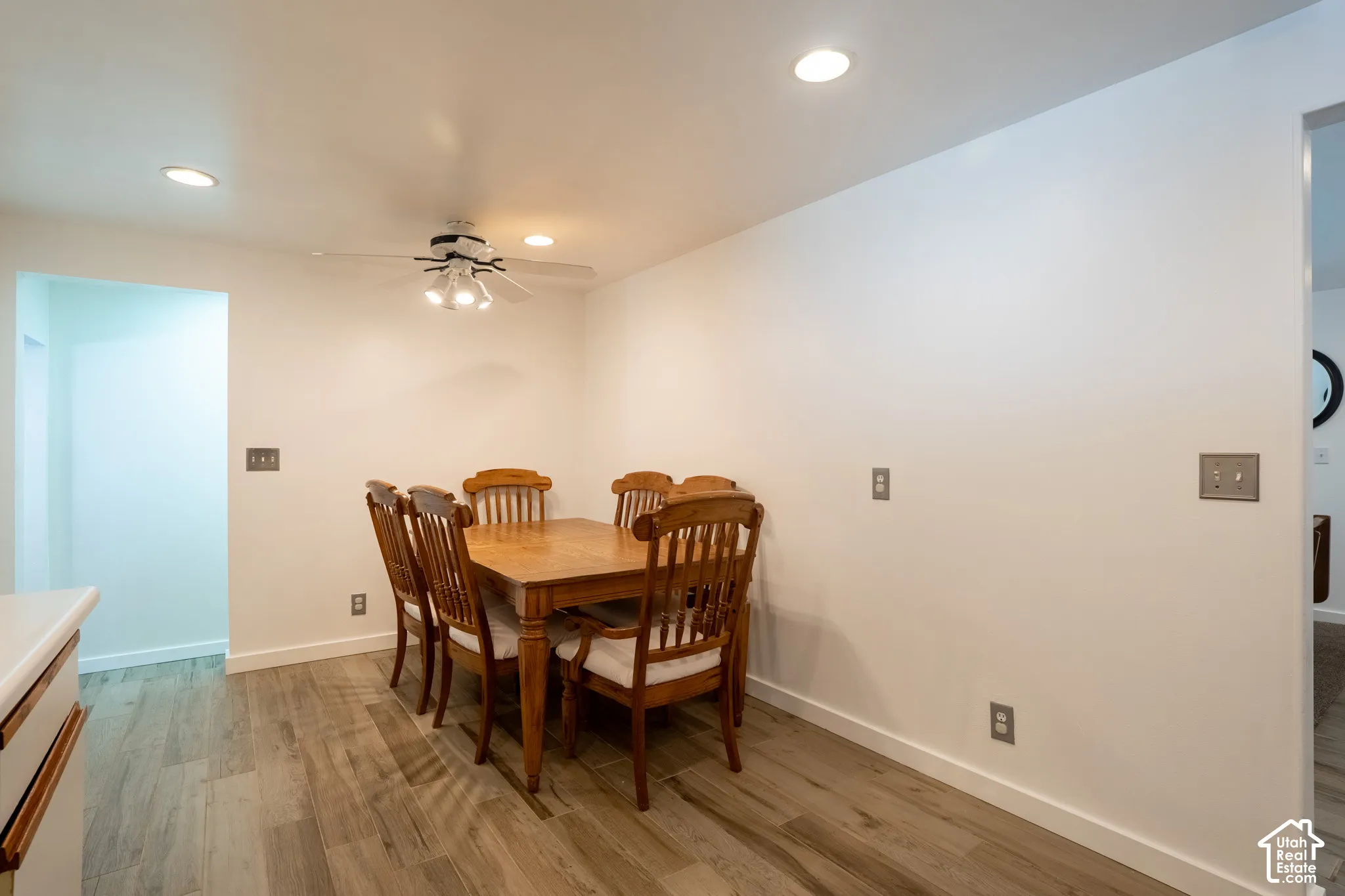 Recessed lighting, ceiling fan light fixture, wood-finish flooring, and white wall finishes