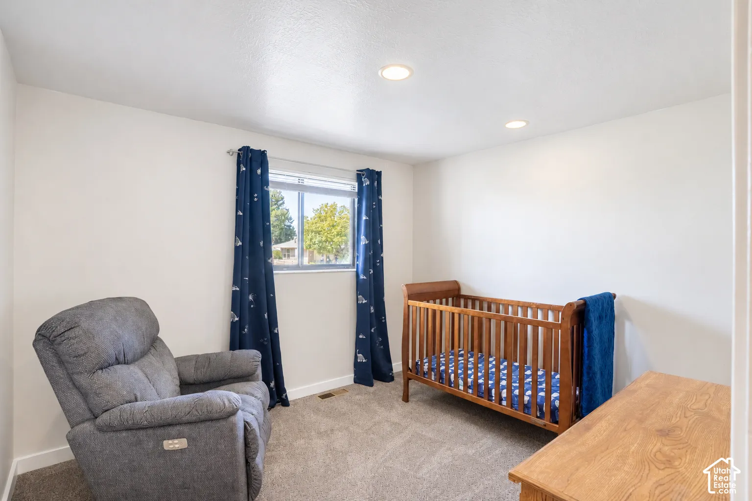 Neutral wall paint, recessed lighting, window with a window treatment, and carpeted flooring