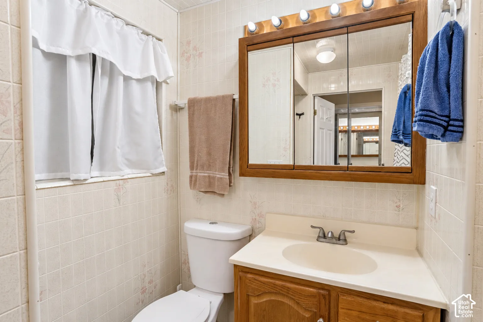 Wood-finish vanity with an integrated sink and chrome faucet