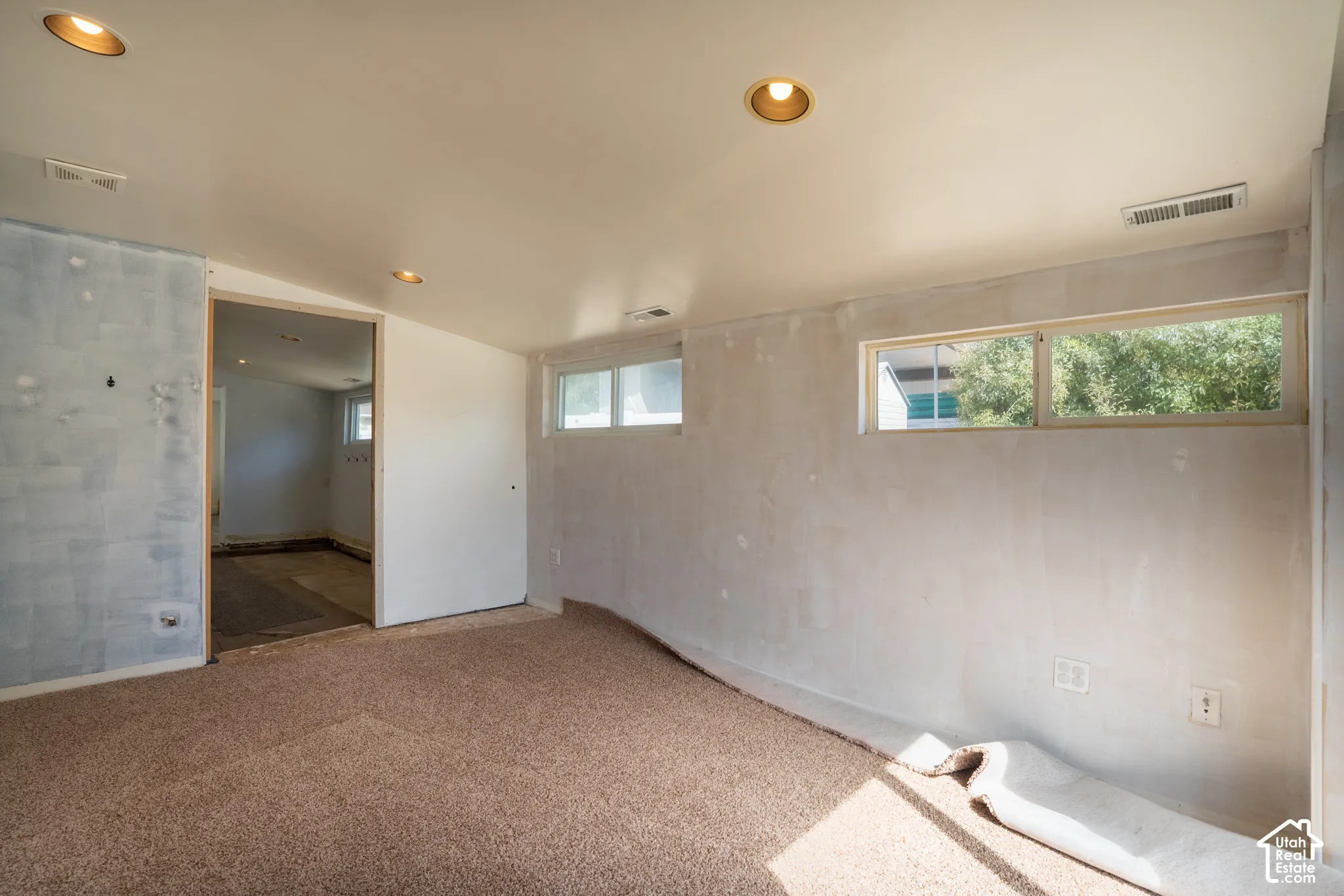 Recessed ceiling lighting, multiple windows, and a doorway