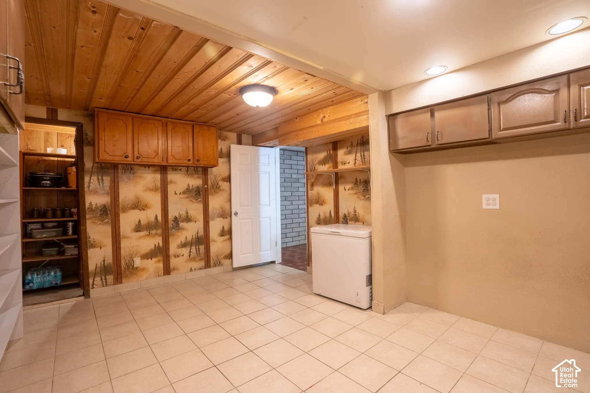 Wood-paneled ceiling, recessed lighting, tile flooring, built-in shelving, and upper cabinetry