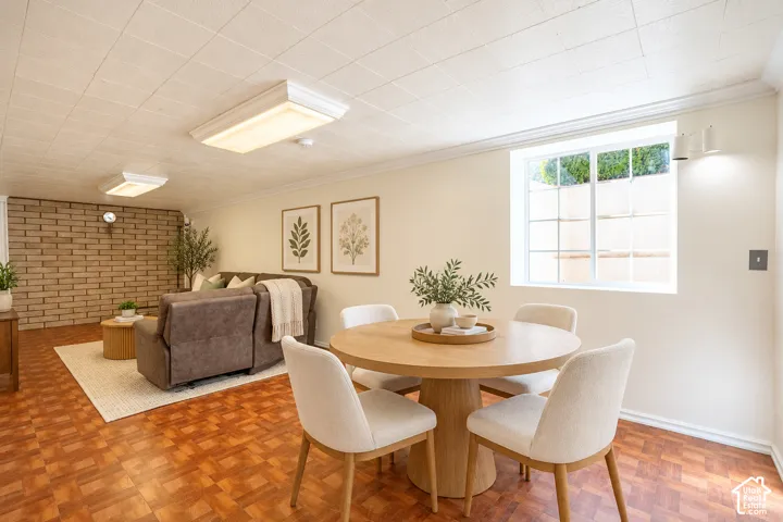 Recessed window, wood-finish flooring, exposed brick wall, crown molding, and flush-mount lighting fixtures